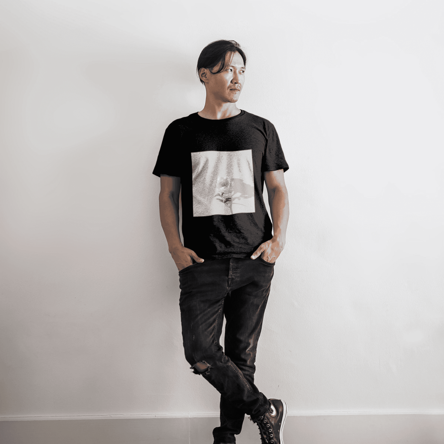 Man wearing a black t-shirt featuring a single white rose graphic design.