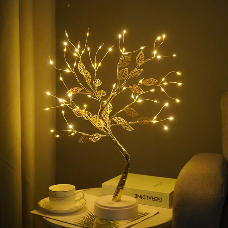 Wireframe tree sculpture with LED lights and handcrafted leaves, adding warm ambiance to a cozy setting.