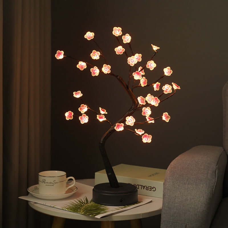 Decorative wire tree sculpture with LED cherry blossoms illuminating a cozy room.