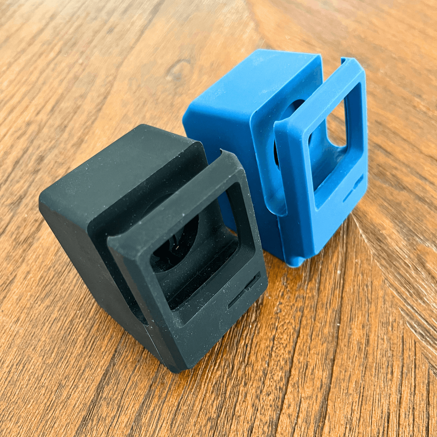 Rubberized silicone retro watch stands in black and blue colors, designed for charging iWatches.
