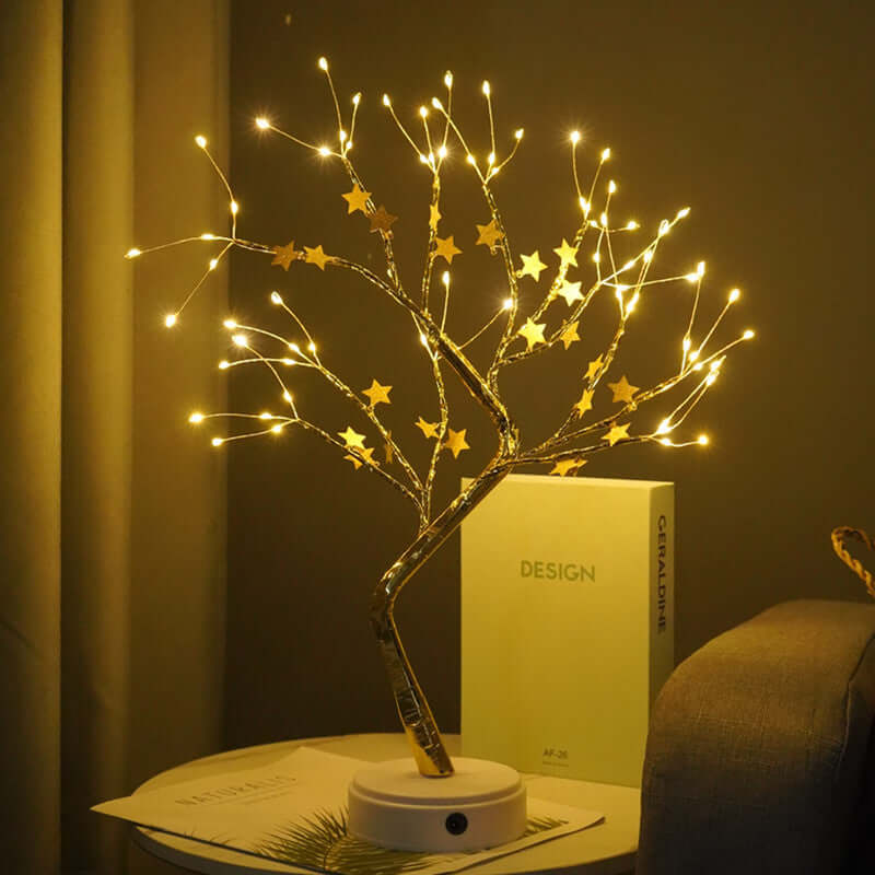 Decorative wire tree with LED star lights on a table, creating an ambient atmosphere in a cozy room.