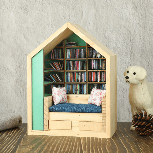 Miniature house-shaped bookshelf with tiny shelves, a cozy couch, decorative pillows, and a polar bear figurine.