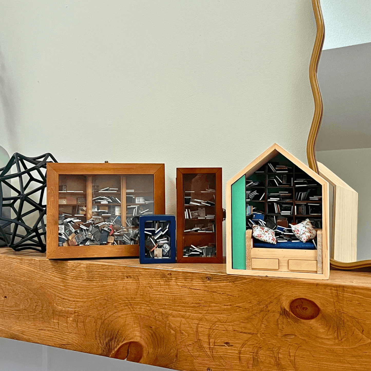 Four Piece Anxiety Bookshelf Collection Bundle displayed on a wooden shelf, featuring miniatures of books and a cozy scene.