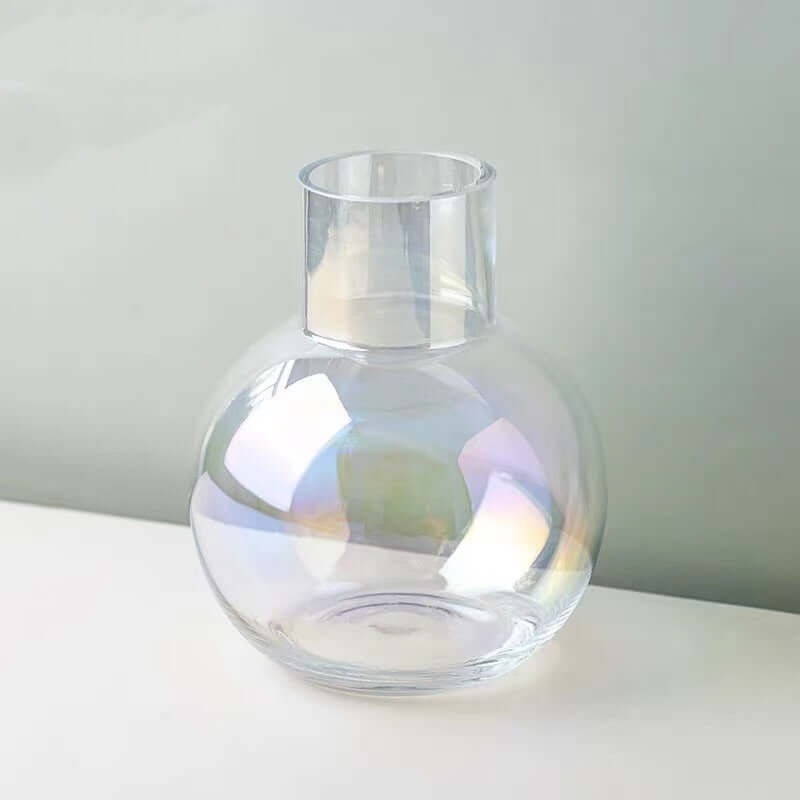 Iridescent glass sphere vase showcasing soft color shifts in sunlight against a minimalist backdrop.