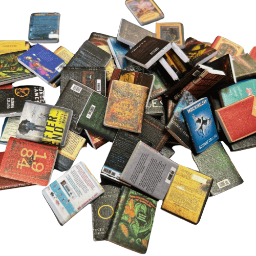 A collection of miniature books from the Four Piece Anxiety Bookshelf Collection Bundle scattered on a surface.