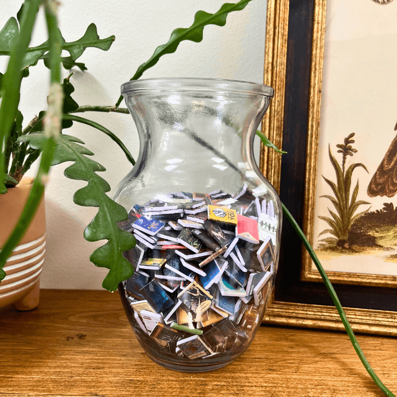 A clear vase filled with the mini books that come with the anxiety bookshelf.