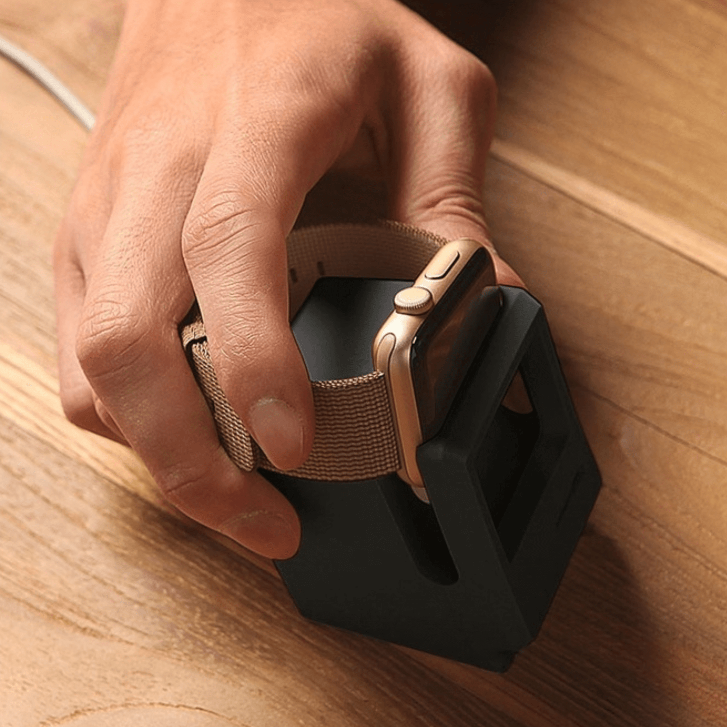 A hand placing an iWatch on a retro computer-style silicone stand, perfect for display and charging.