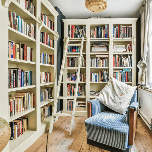 A beautiful white bookshelf filled with books.