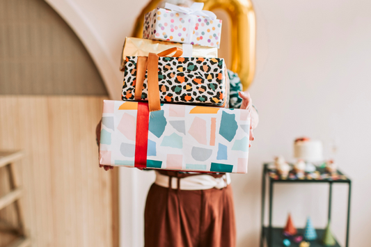 Holding a stack of gifts from Sydney's best gift collection