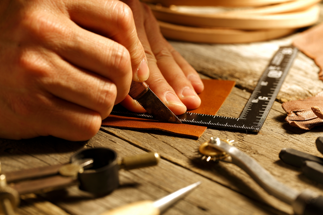 Cutting leather for handmade stitching.