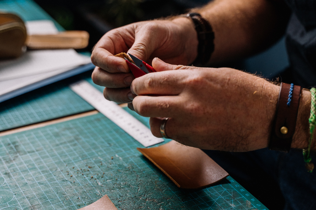 Stitching leather by hand.