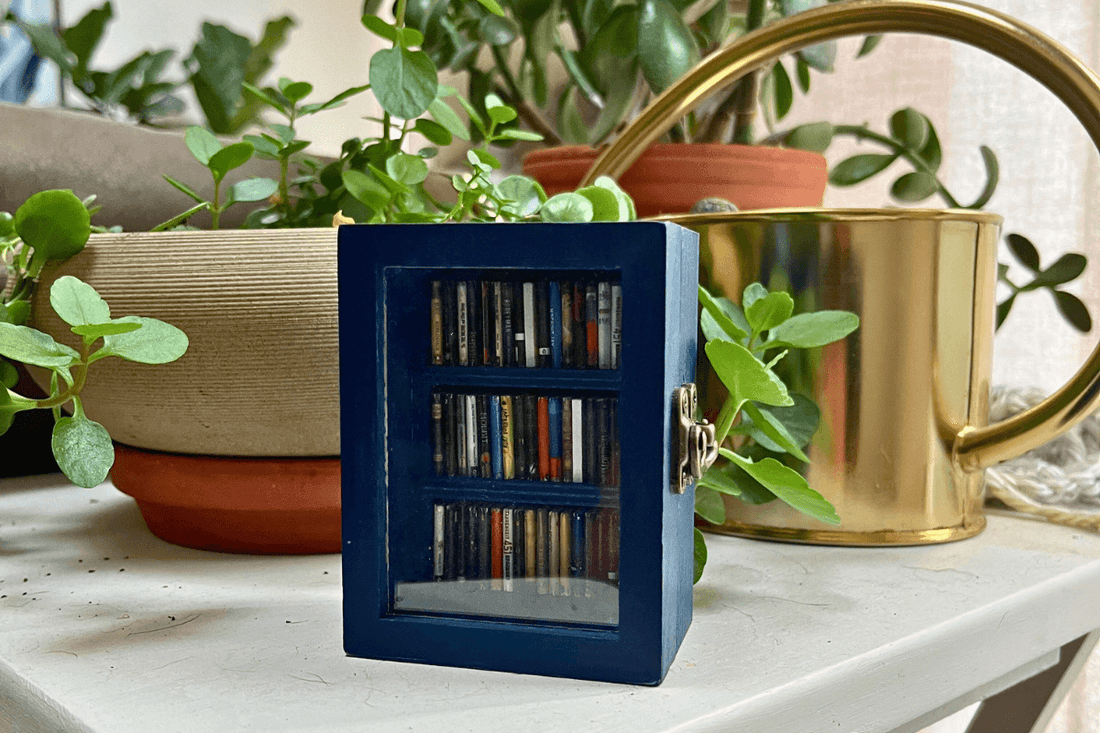 The mini blue pocket anxiety bookshelf filled with mini books to organize and shake away stress.