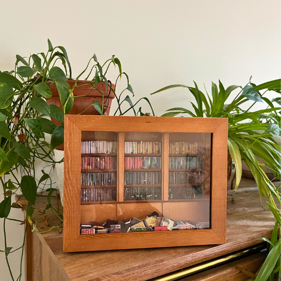 Three Anxiety Bookshelf Bookcases are displayed on a dark wood grain table.