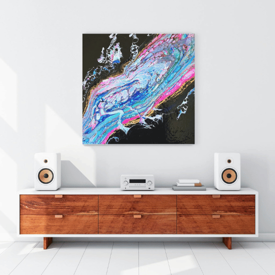 An abstract pour painting is displayed on a wall. The painting resembles a neon coloured hurricane from above.