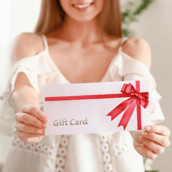 An attractive woman hands a gift certificate towards the camera.