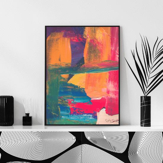 A colorful abstract painting sits on a neutral coloured mantle.