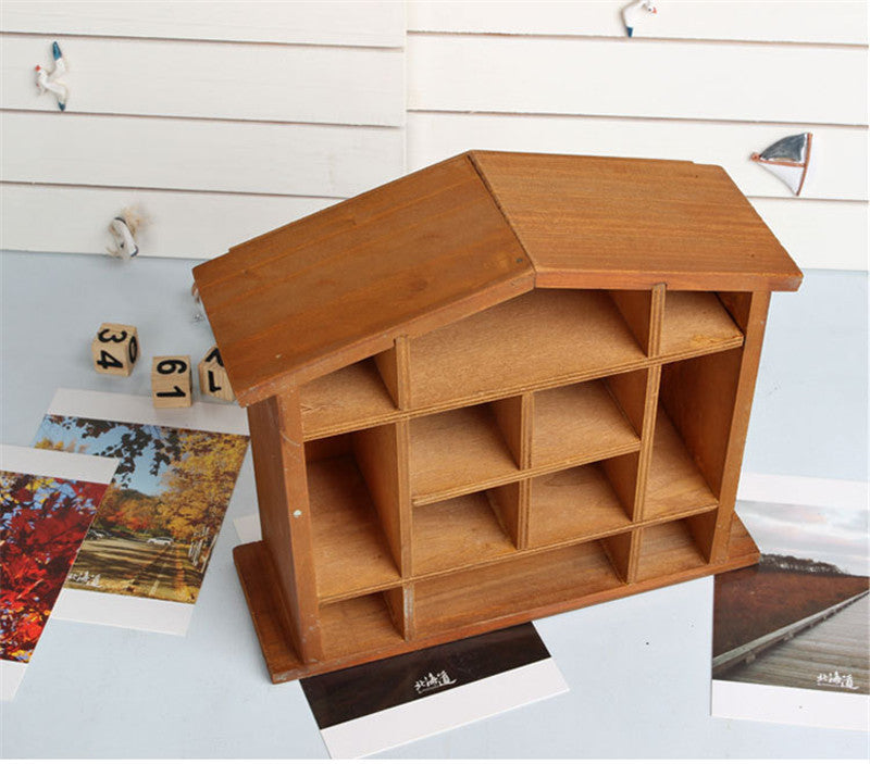 Wood floating shelf that is shaped like a house. It features twelve compartments in a rack style storage area.