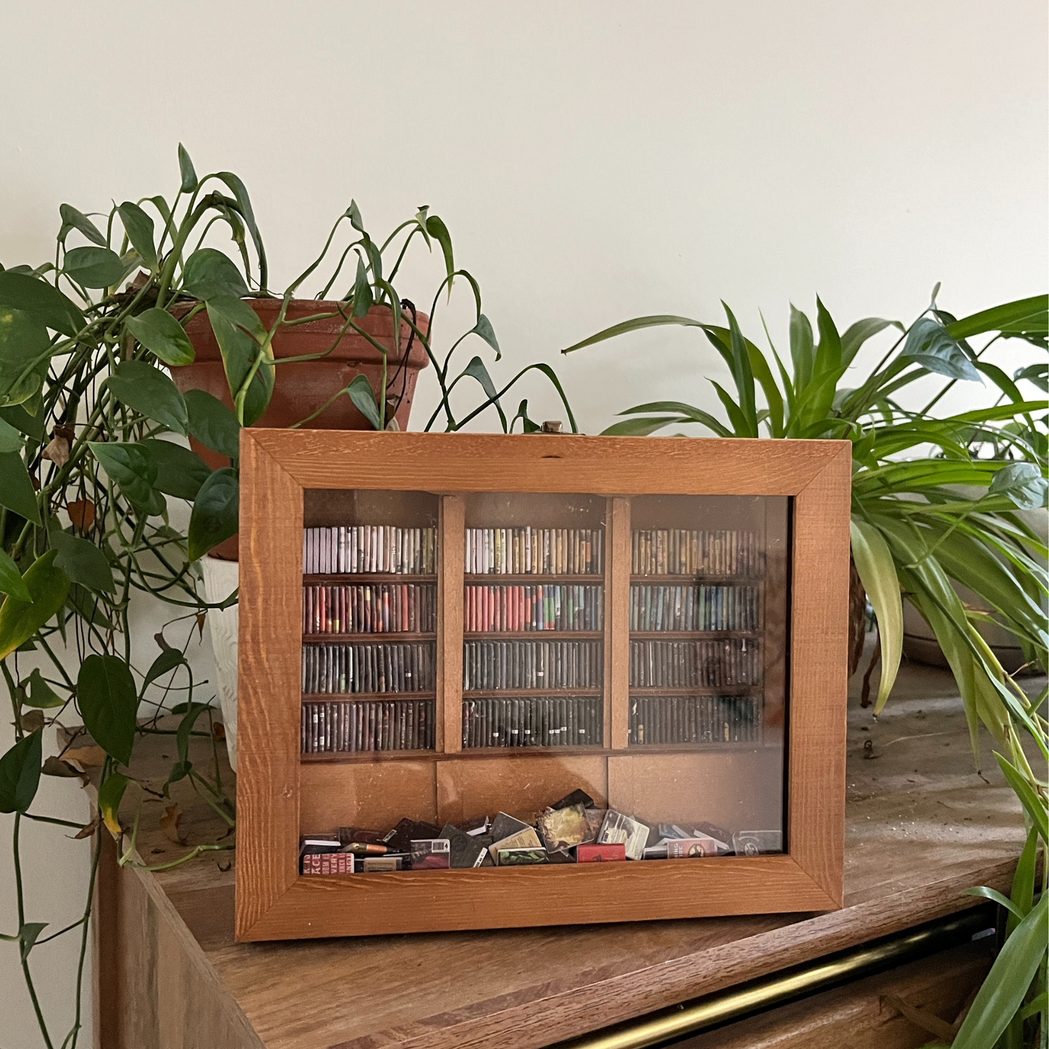 The Anxiety Bookshelf, a handmade wood stress relief library box and shaker shelf fidget toy with mini books, organized by colour gradient.