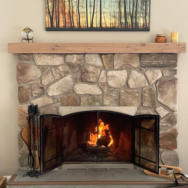 Handmade mantel cap sits overtop the original mantel for an easy fireplace upgrade.