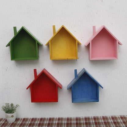 A handmade house shaped floating bookshelf available in green, white, gold, red, pink, and blue.