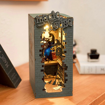 A green, magic themed book nook sits on a table.