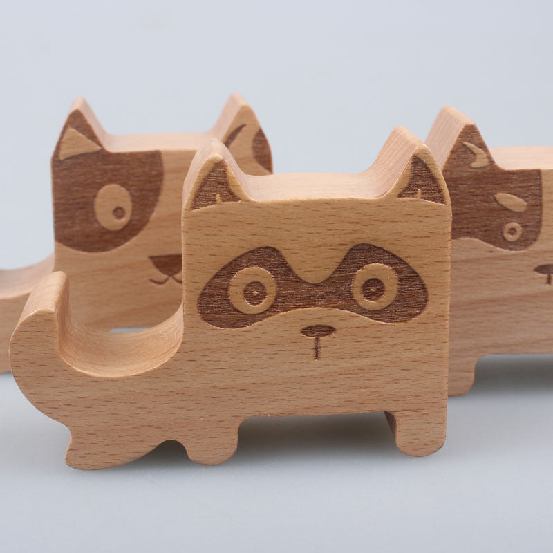 Wood animal shaped phone stand featuring a cute raccoon design, perfect for functional home decor.