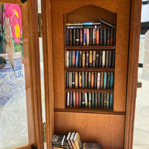 Inside the Anxiety Bookcase. Miniature books inside a miniature antique bookshelf.