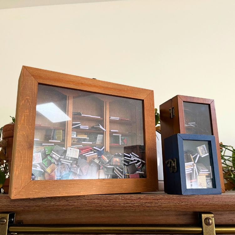 Anxiety Bookshelf Collection sits closed as shelf decor. Filled with mini books, this collection features the Original, Pocket, and Anxiety Bookcase.