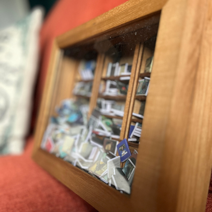 Anxiety Bookshelf mini bookcase sits on an orange couch. 