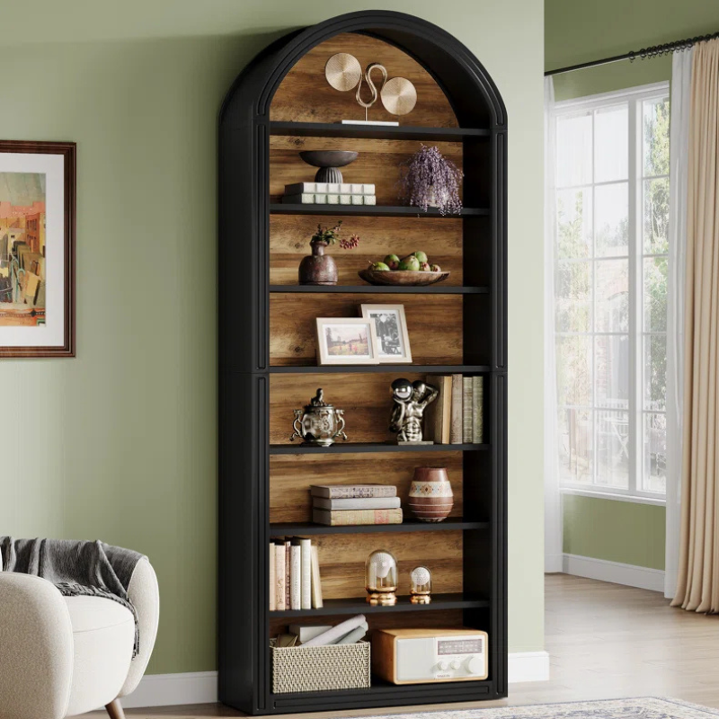 A tall and narrow black arched top bookshelf with wood grain backing. An open faced unique bookshelf for tight spaces.