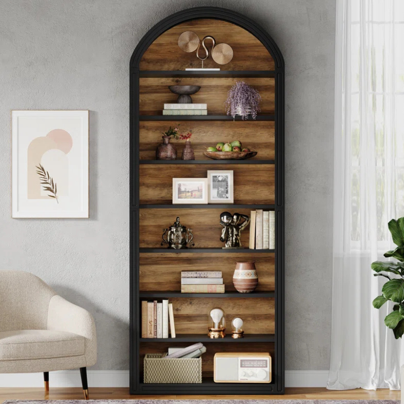 A tall and narrow black arched top bookshelf with wood grain backing. An open faced unique bookshelf for tight spaces.