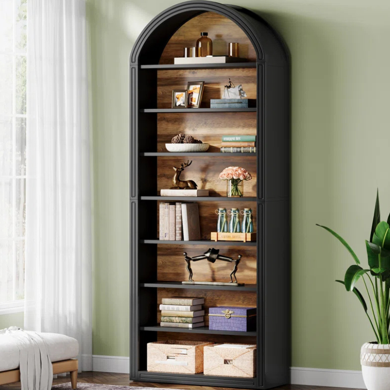 A tall and narrow black arched top bookshelf with wood grain backing. An open faced unique bookshelf for tight spaces.