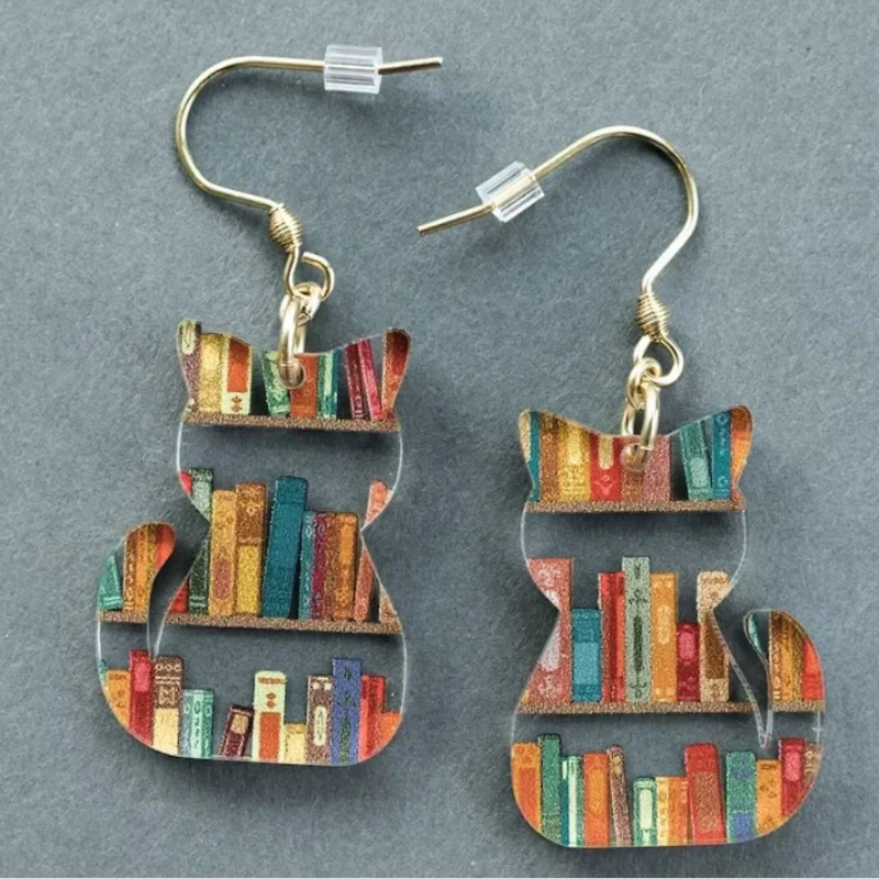 Clear acrylic cat shaped mini bookshelf earrings with colourful books inside.