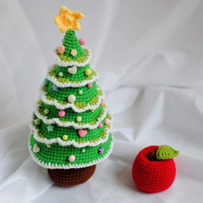 Handmade crochet christmas tree plushie is displayed with a crochet apple plushe.