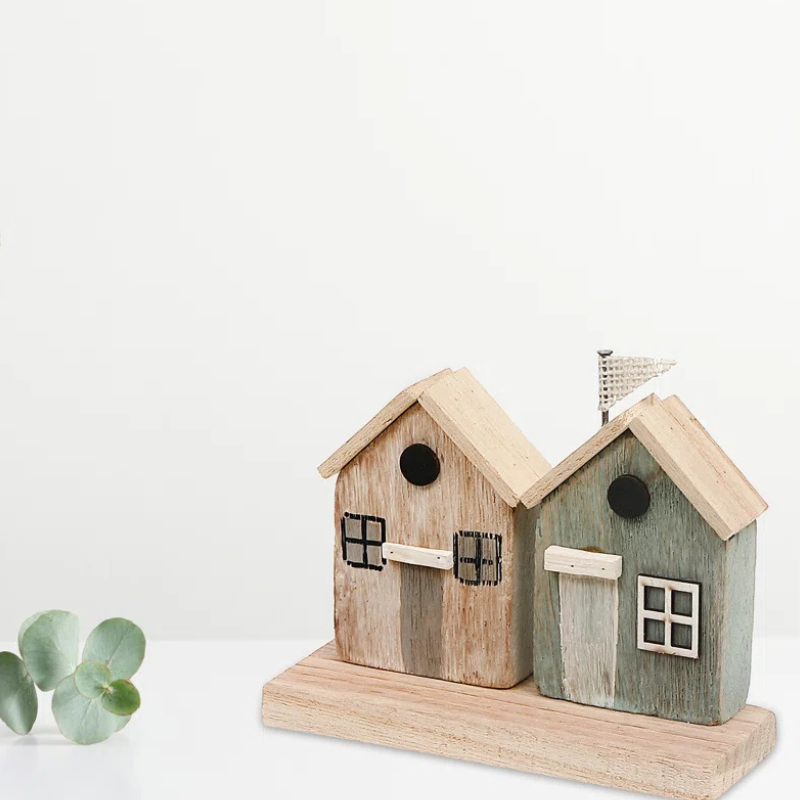 Handmade coastal themed wood houses. A two-house figurine set sits on a wood slab.