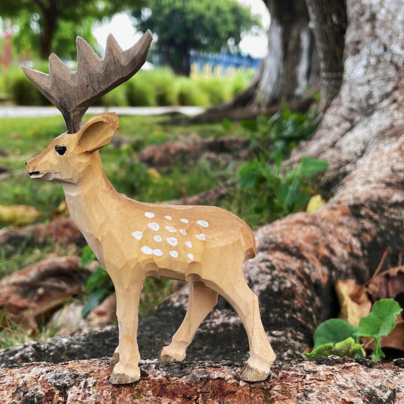 Hand-carved wooden deer ornament showcasing intricate detail and natural textures, perfect gift for deer lovers.