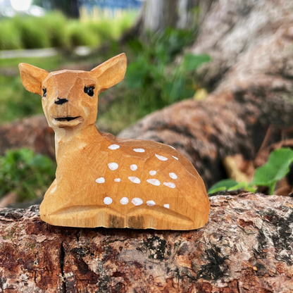 Hand-carved wooden deer ornament showcasing detailed craftsmanship and natural wood textures.