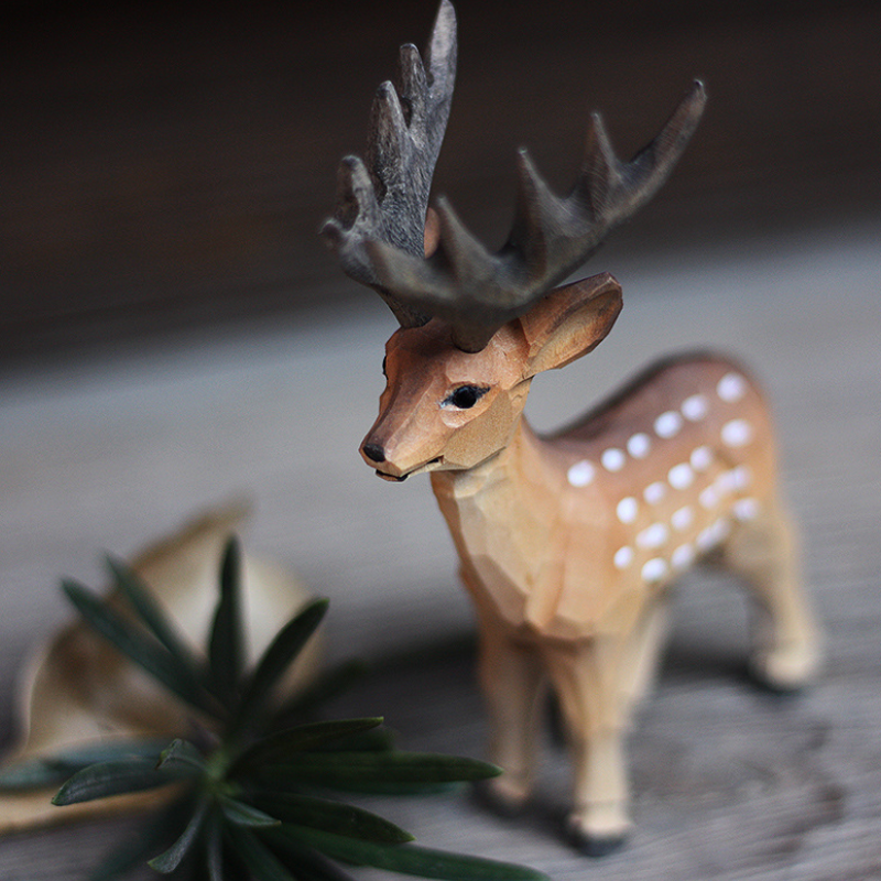 Hand-carved wooden deer ornament showcasing unique details and natural wood textures, perfect for animal lovers.