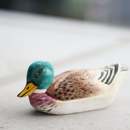 Hand-carved wooden duck ornament showcasing detailed craftsmanship and vibrant colors.