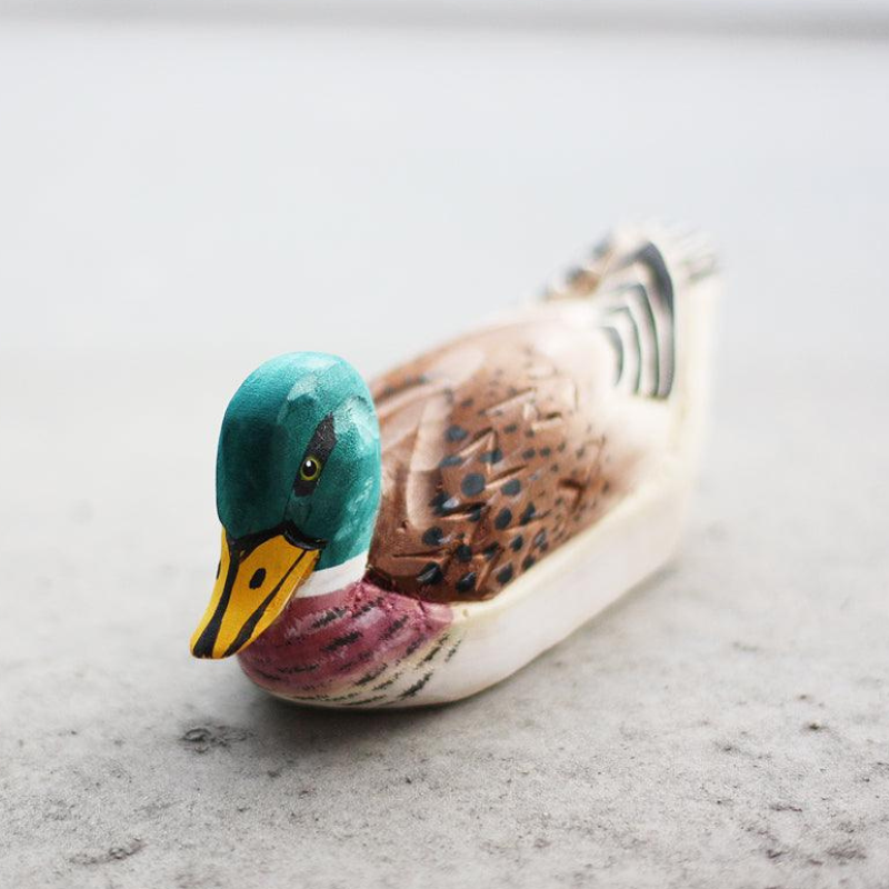 Hand-carved duck ornament showcasing detailed craftsmanship and natural wood textures, perfect gift for duck lovers.