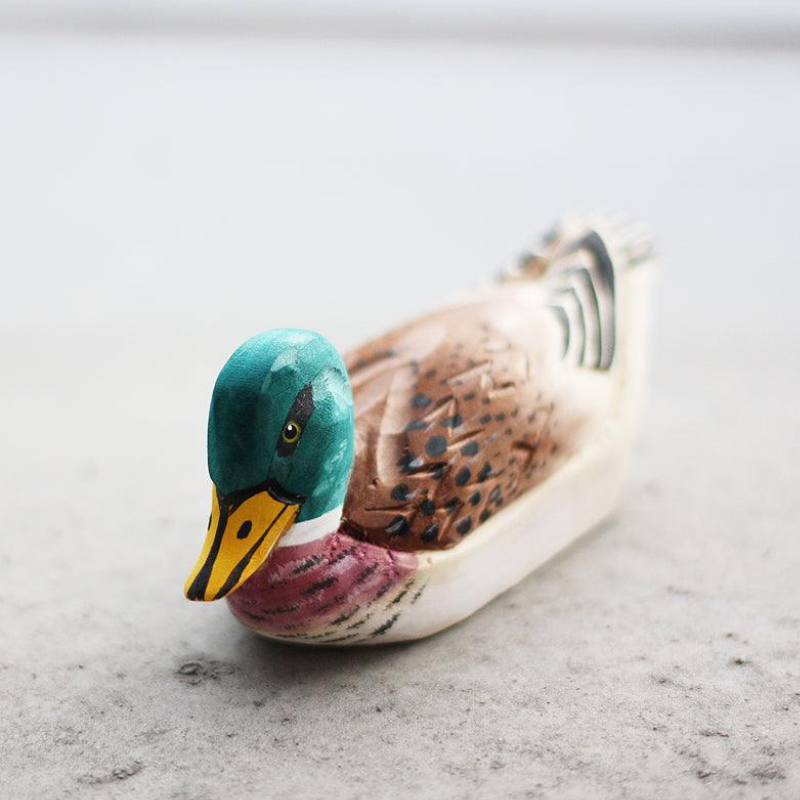 Hand-carved wooden duck ornament showcasing detailed craftsmanship and natural wood textures, perfect for duck lovers.