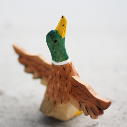 Hand-carved wooden duck ornament with outstretched wings and vibrant colors, perfect for duck lovers.