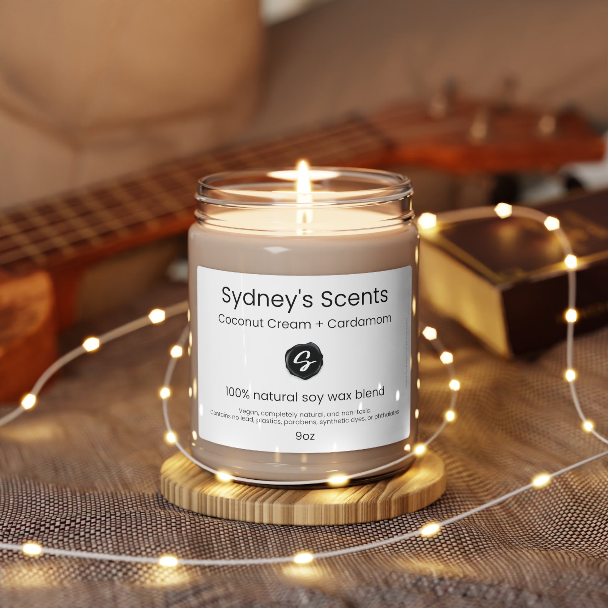 A luxurious glass jar soy candle is lit, the scent featured is coconut cream.