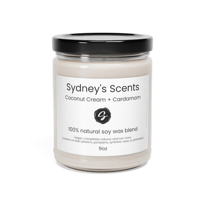 A luxurious glass jar soy candle is lit, the scent featured is coconut cream and cardamom.