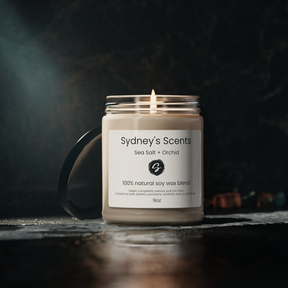 A luxurious glass jar soy candle is showcased, the wick is lit, and the scent is Sea Salt and Orchid.