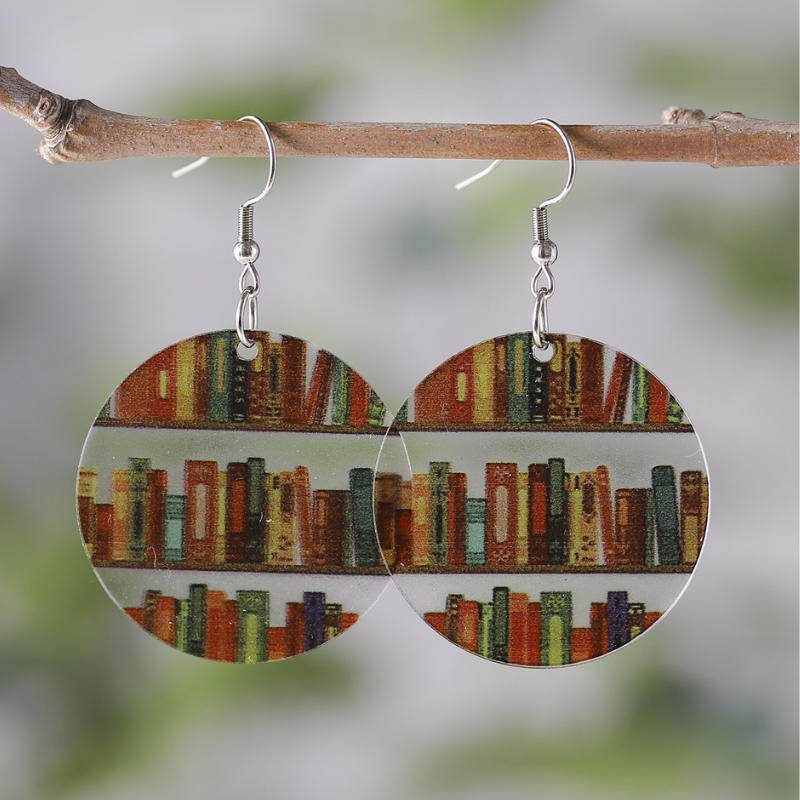 Clear acrylic circle shaped mini bookshelf earrings with colourful books inside.