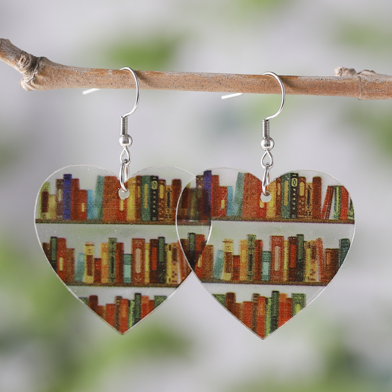 Clear acrylic heart shaped mini bookshelf earrings with colourful books inside.