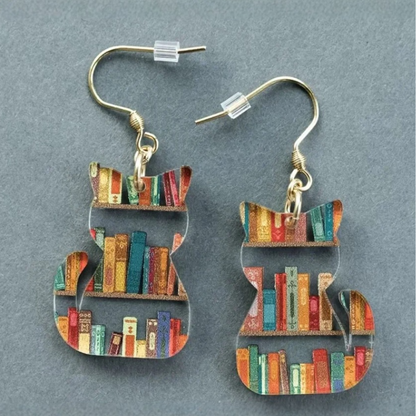 Clear acrylic cat shaped mini bookshelf earrings with colourful books inside.