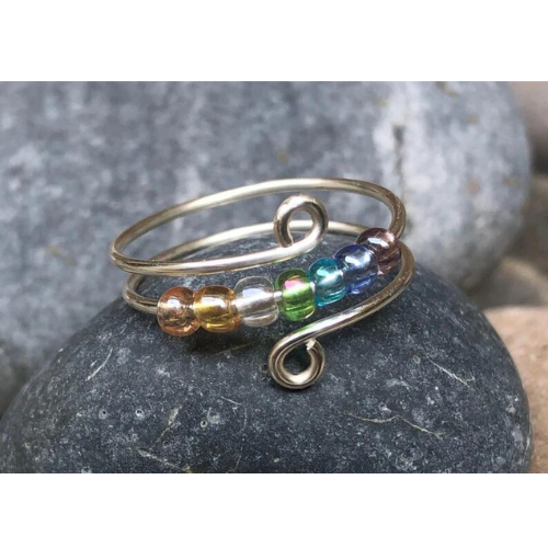 Close up image of a rainbow beaded anxiety ring for fidgetting.