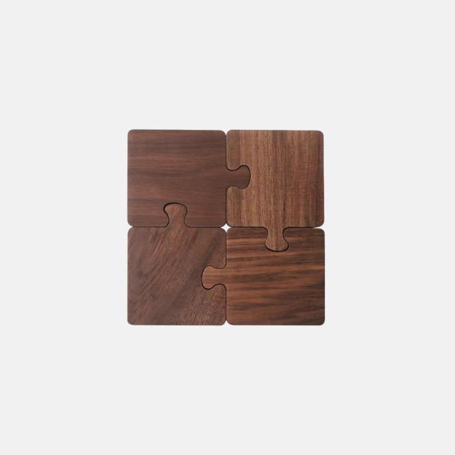 A dark stained wood puzzle piece coaster set of four.